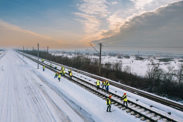 Excavatoare multifuncționale feroviare montând șine pe traverse beton pe tronsonul Lugoj Timișoara în lucrări modernizare cale ferată pentru viteze trenuri crescute | sursa foto: Economica