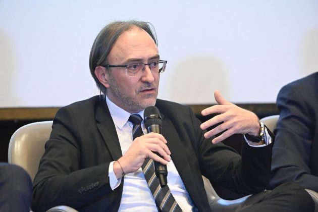 Panou solar și turbine eoliene integrate într-un peisaj industrial, ilustrând tranziția energetică și impactul asupra pieței energiei și prețului energiei electrice. | sursa foto: Economica